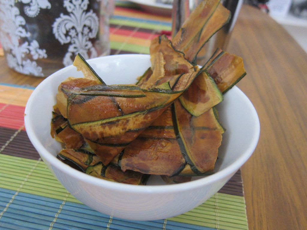 Cesto de air fryer com fatias de abobrinha prontas para assar