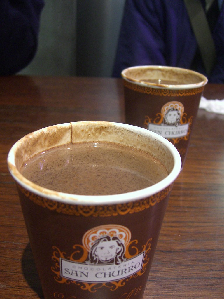 Churros sendo mergulhados em doce de leite cremoso