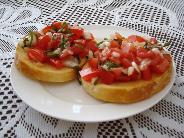 Fatias de bruschetta de tomate e manjericão sobre pão tostado