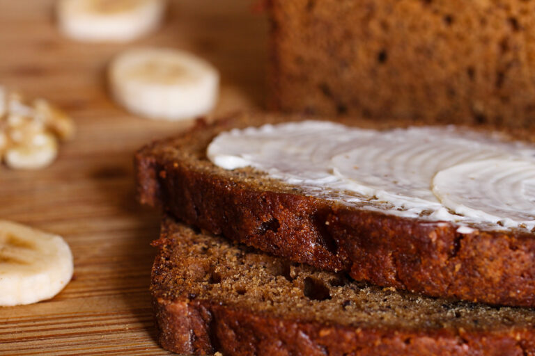 Fatias de bolo de banana com manteiga sobre tábua de madeira