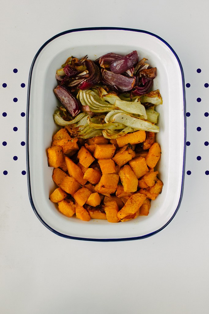 Legumes assados dourados em travessa esmaltada