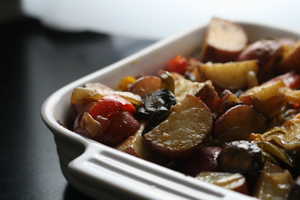 Legumes assados com batatas em travessa branca
