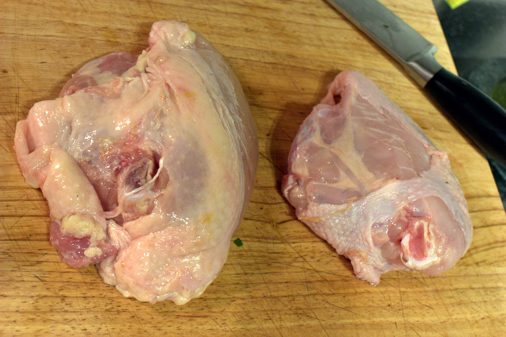 Peitos de frango crus na tábua antes do cozimento