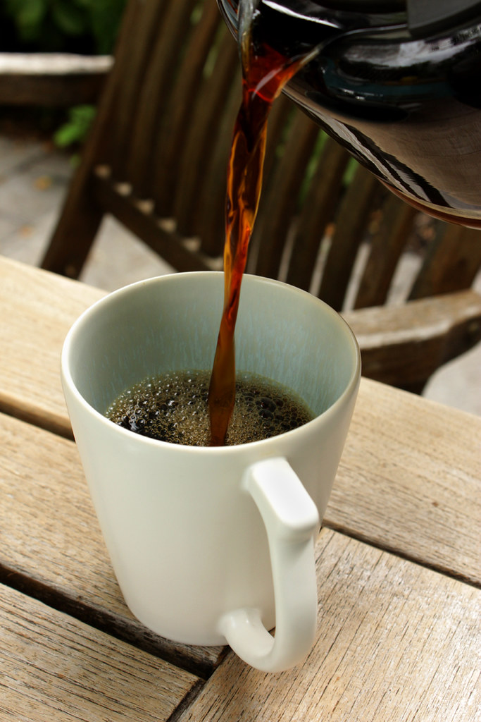 Caneca de cerâmica branca sobre mesa de madeira