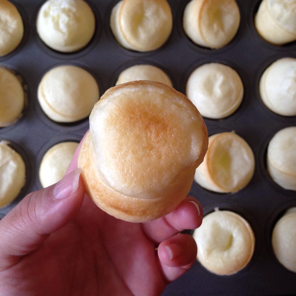 Pães de queijo assando em forma de muffin, vistos de cima